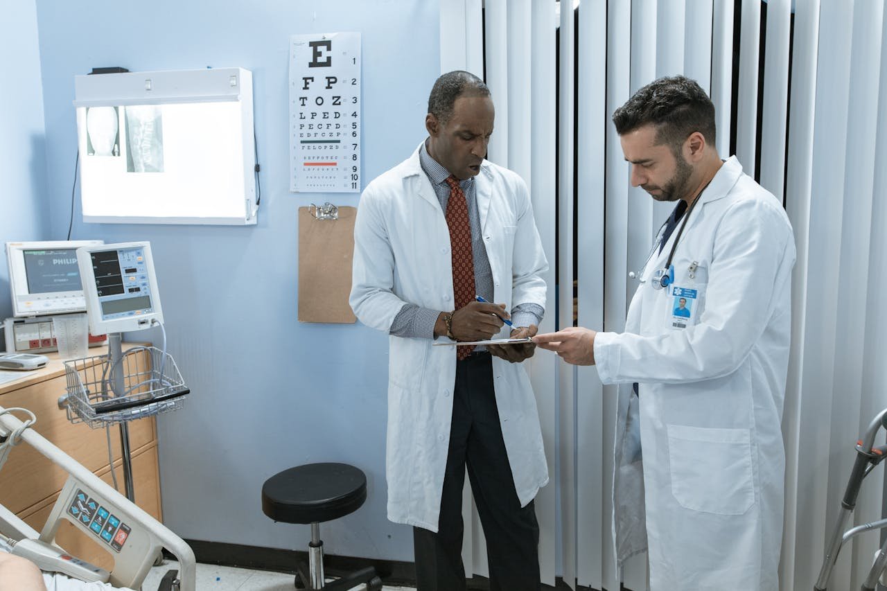 Two doctors in lab coats discussing a patients medical chart in a hospital setting.